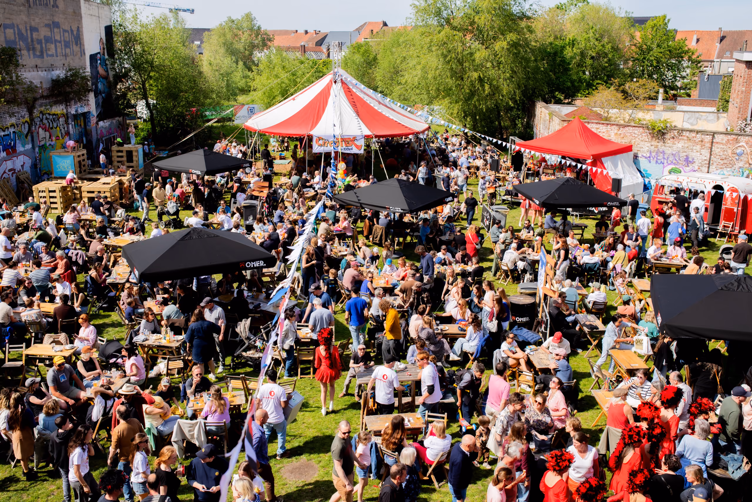 Het V-TEX terrein vol bezoekers, tenten en picknicktafels tijdens een vorige editie van TEXtival